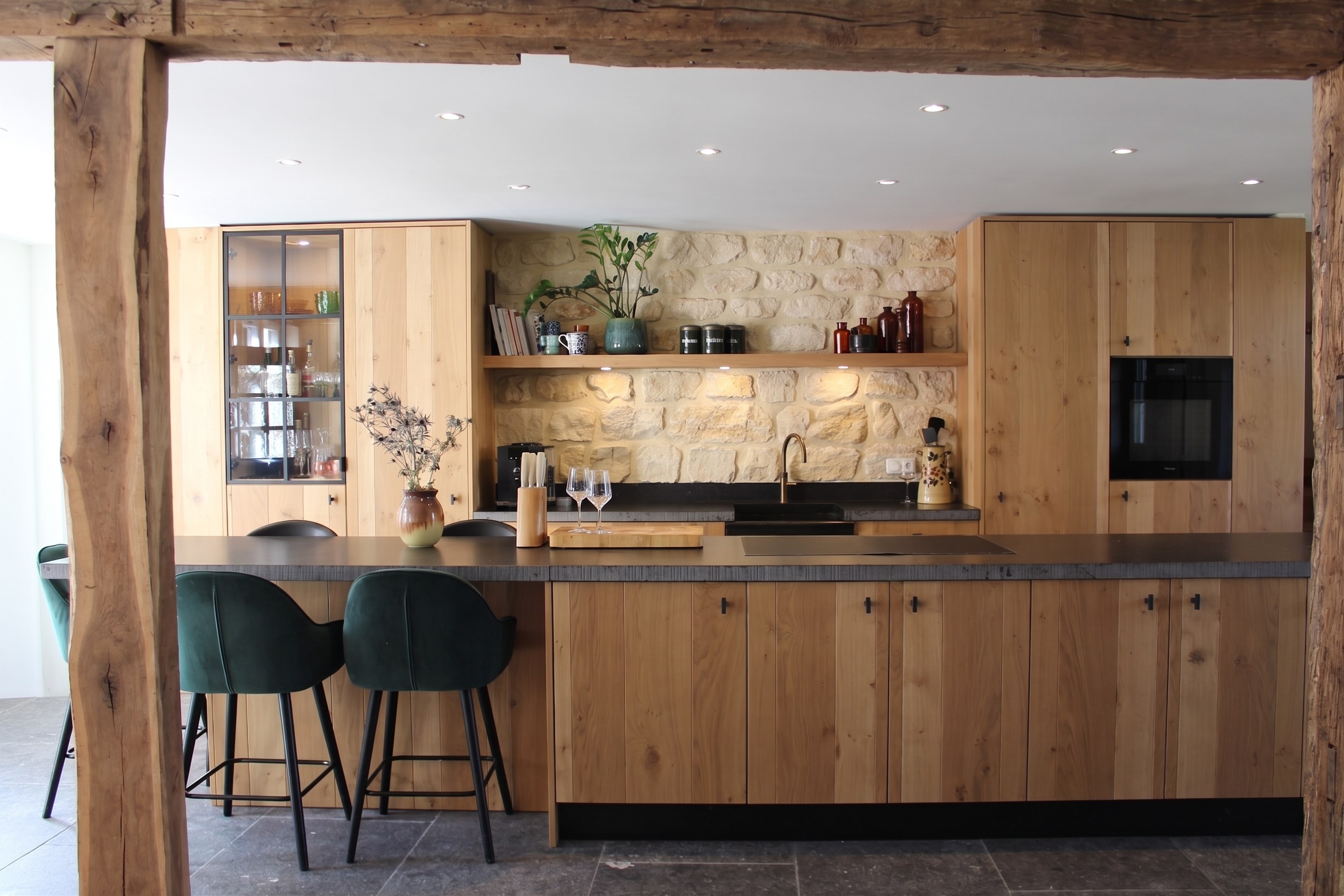 Open keuken met kunradersteen achterwand en originele houten gebinten